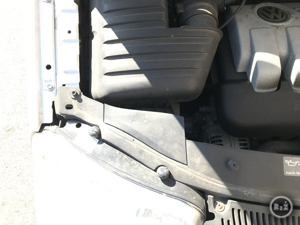 Fotografie - pohled na levý světlomet - šrouby a krytky, které je nutné vyndat - pro výměnu předního světla osobního automobilu VW Sharan