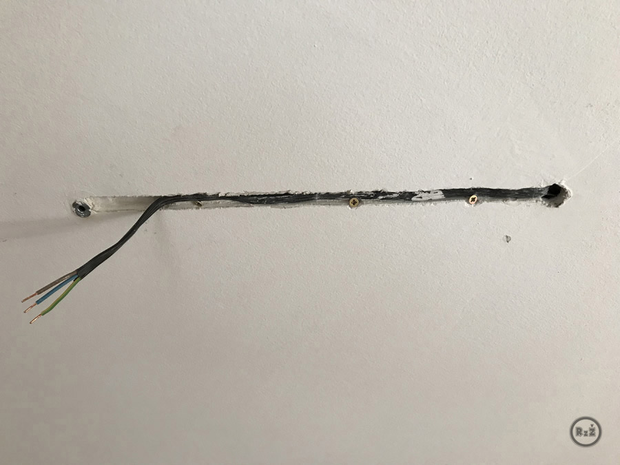 díra v sádrokartonu ve kterém je šroubky připevněný kabel čekající na zatmelení | Rady ze života