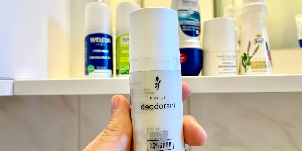 Nejlepší tekutý deodorant rakouské značky Ringana zblízka v detailu v pozadí s poličkou v koupelně s dalšími již odzkoušenými tekutými deodoranty, které neuspěly ve srovnání s Ringanou - téměř dokonalé ověřené složení